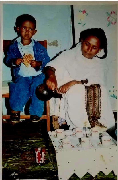 Nigisti Hailu with her son Abraham, dressed in traditional holiday attire and hosting a coffee ceremony.