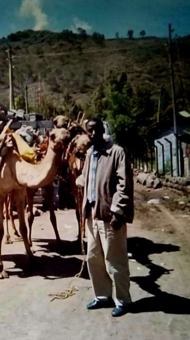 Professor Meareg Amare visiting his hometown in Tigray, pictured beside a camel.