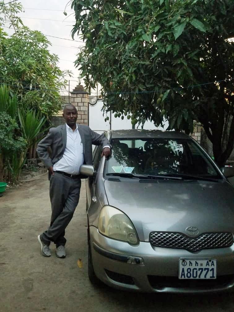 Professor Meareg Amare beside his personal vehicle at his family home, 2017.